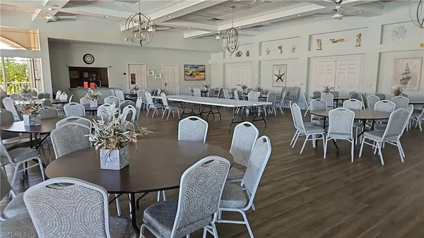 a dining room with furniture a chandelier and wooden floor