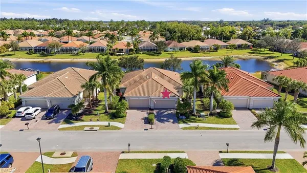 an aerial view of residential houses with outdoor space and lake view