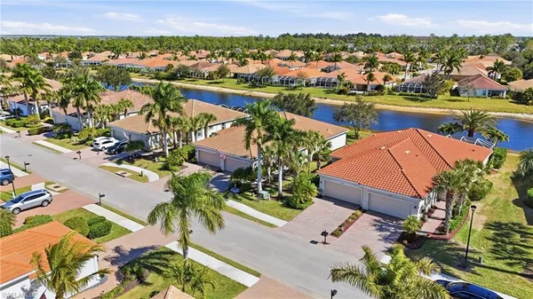 an aerial view of residential houses with outdoor space and lake view