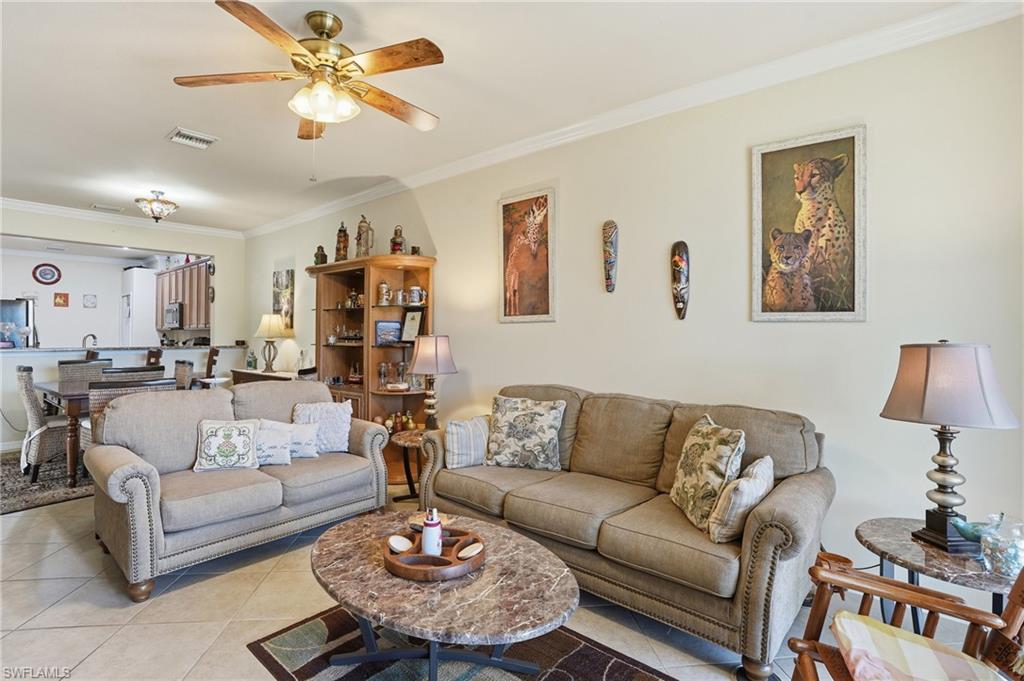 14536 Grapevine Drive Naples, FL 34114 - Photo 10 of 39 Tiled living room with ornamental molding and a ceiling fan