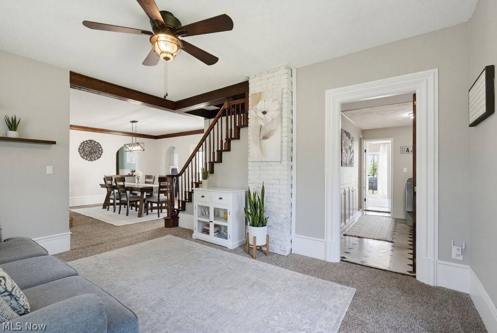 23055 Snell Road Columbia Station, OH 44028 - Photo 24 of 50 Open concept living area featuring a ceiling fan with integrated lighting, a staircase with wood banister and white risers, and a dining area with arched entryways