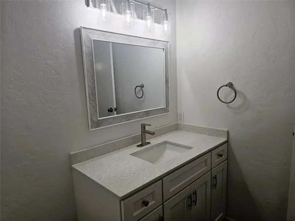 a bathroom with a sink vanity and a mirror