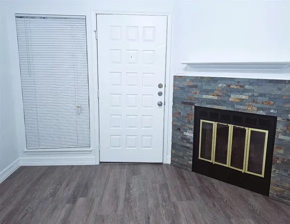 an empty room with wooden floor and fireplace