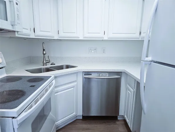 a kitchen with granite countertop white cabinets and a sink
