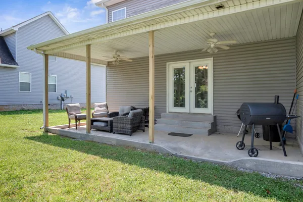 a view of a patio with table and chairs potted plants with wooden floor and fence