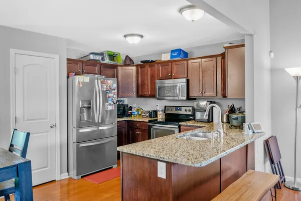 a kitchen with stainless steel appliances granite countertop a refrigerator stove microwave and sink
