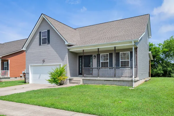 a front view of a house with a garden and plants