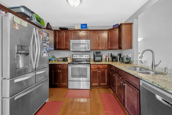 a kitchen with stainless steel appliances granite countertop a refrigerator sink and stove