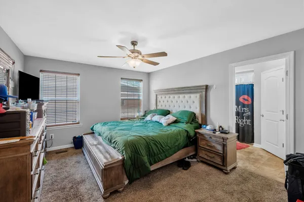 a spacious bedroom with a bed and a flat screen tv