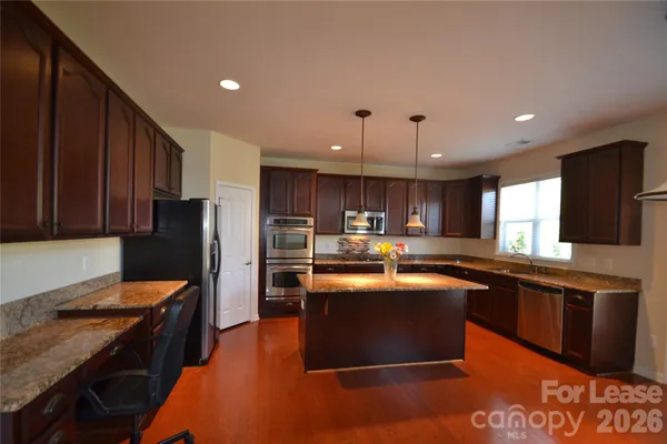a kitchen with stainless steel appliances granite countertop a sink stove and refrigerator