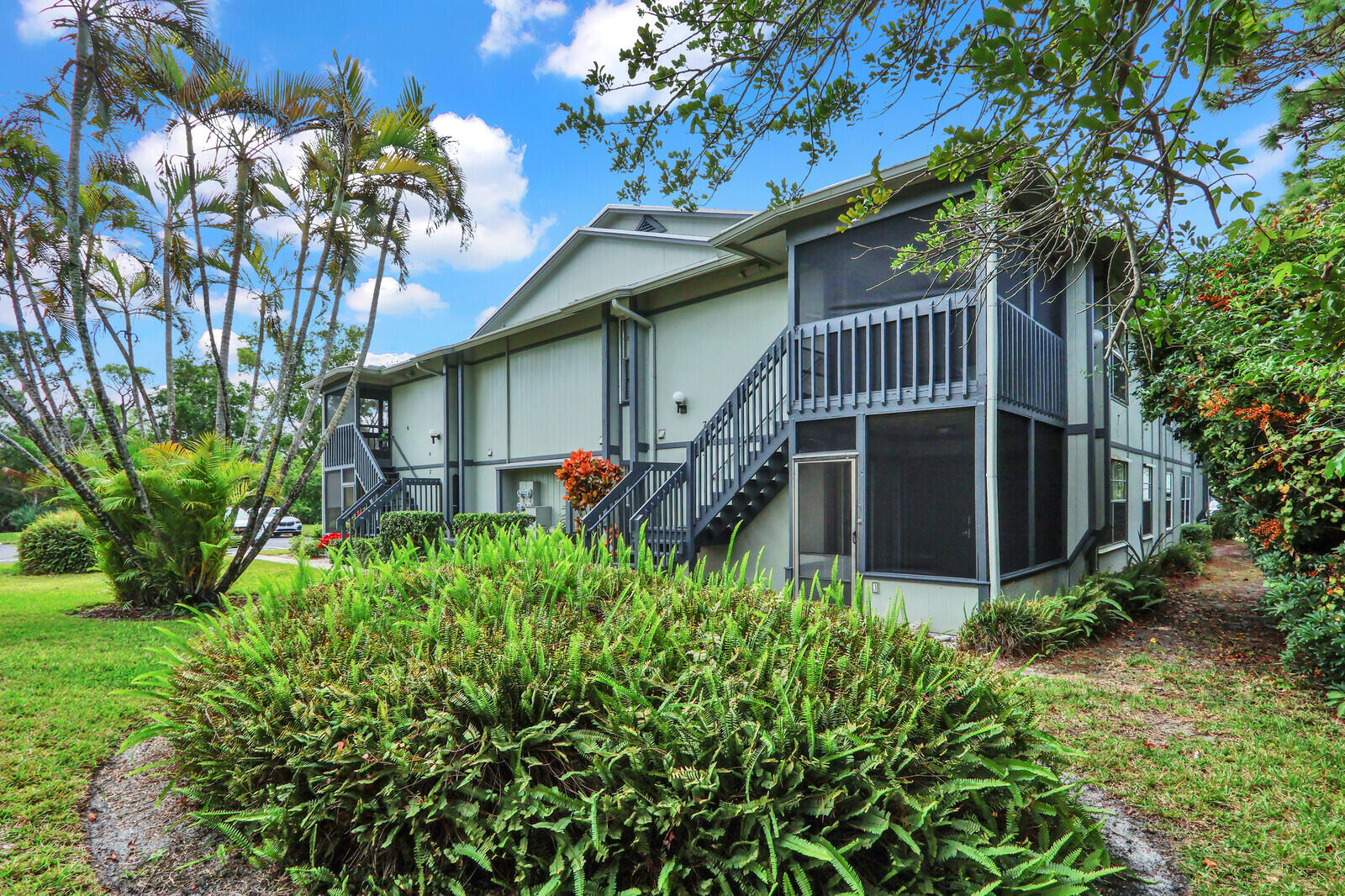 8356 Southeast Croft Circle, Unit O3 Hobe Sound, FL 33455 - Photo 19 of 20 a front view of a house with a yard