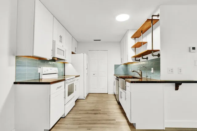a kitchen with stainless steel appliances granite countertop a sink and a stove