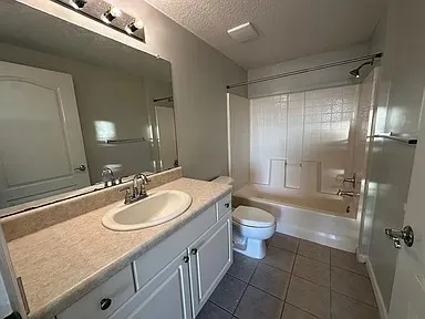 a bathroom with a sink a toilet a mirror and shower