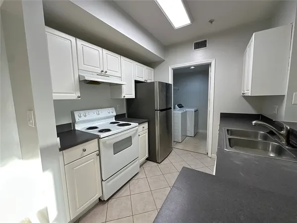 a kitchen with a stove a refrigerator and a sink