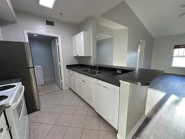 a kitchen with stainless steel appliances a sink a stove a refrigerator a counter top space and cabinets