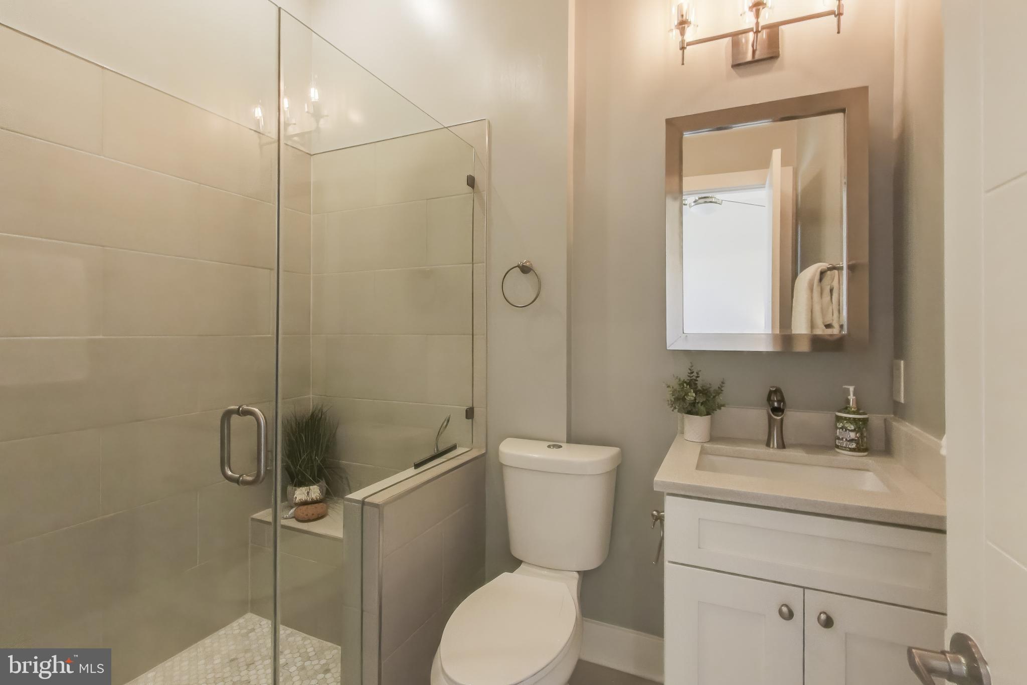 2012 D Street Northeast, Unit 4 Washington, DC 20002 - Photo 13 of 25 a bathroom with a toilet sink vanity and mirror