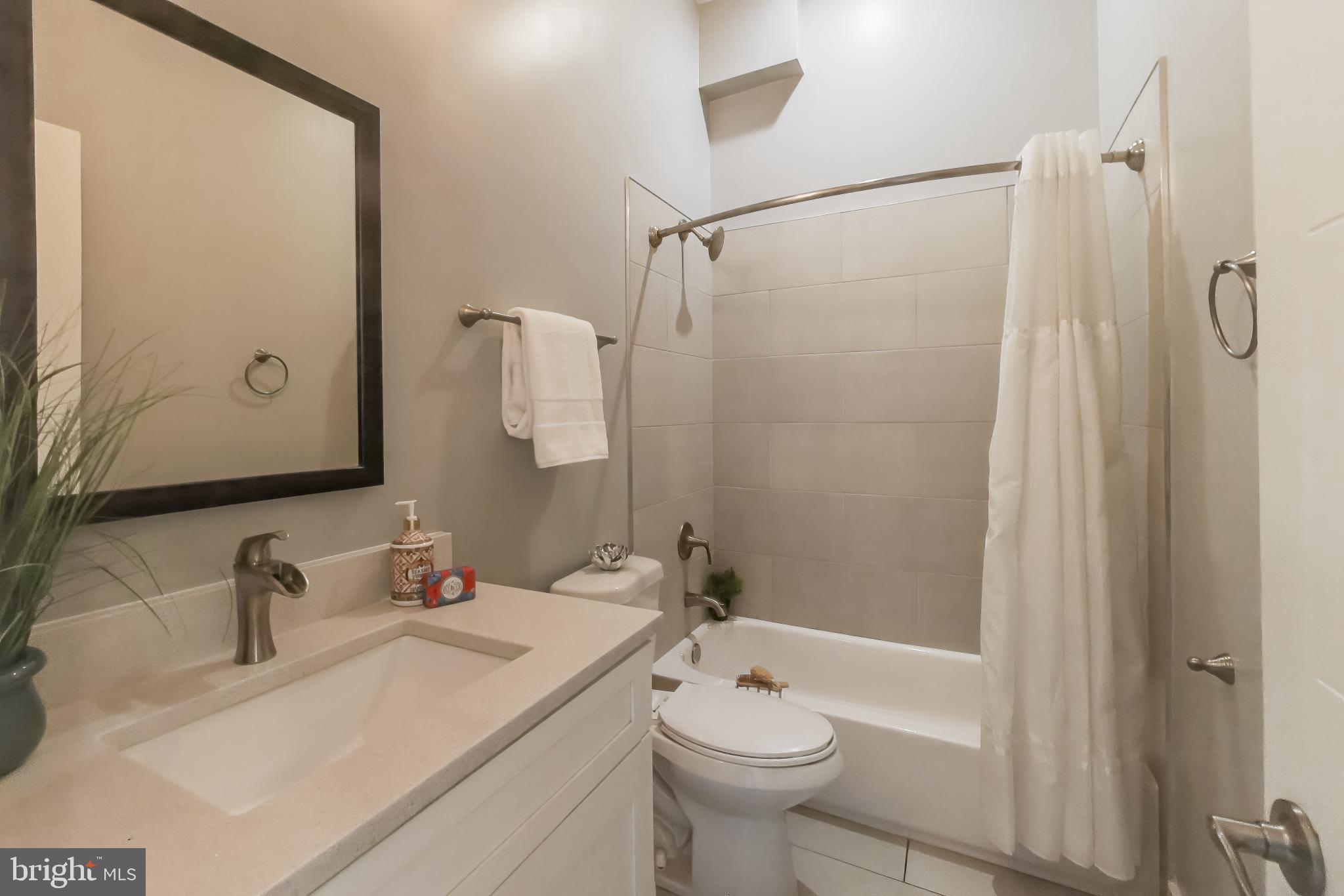 2012 D Street Northeast, Unit 4 Washington, DC 20002 - Photo 18 of 25 a bathroom with a sink toilet a shower and a mirror