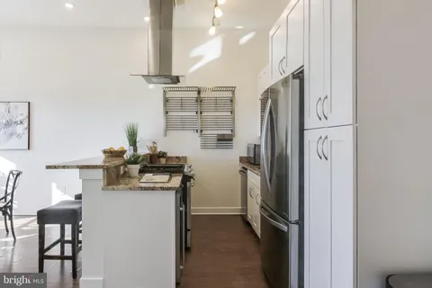 a kitchen with stainless steel appliances granite countertop a refrigerator and a stove