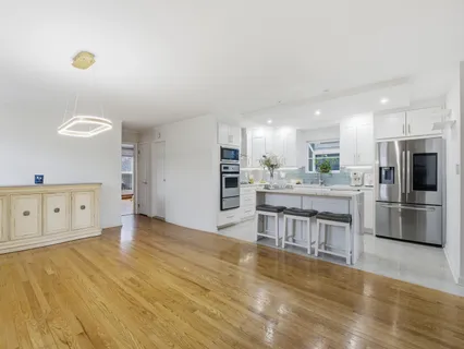 a kitchen with stainless steel appliances kitchen island granite countertop a stove a sink and a refrigerator