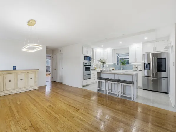 a kitchen with stainless steel appliances kitchen island granite countertop a stove a sink and a refrigerator