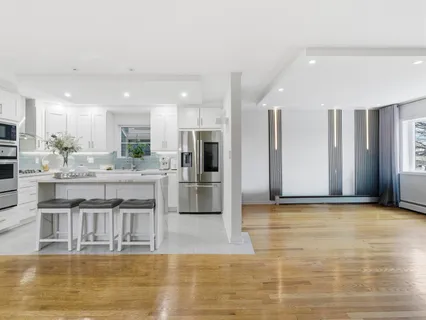 a kitchen with stainless steel appliances granite countertop a refrigerator and a stove top oven