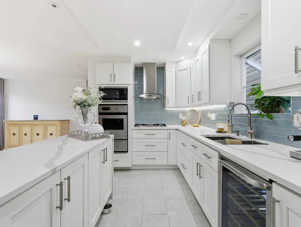 a kitchen with white cabinets and appliances