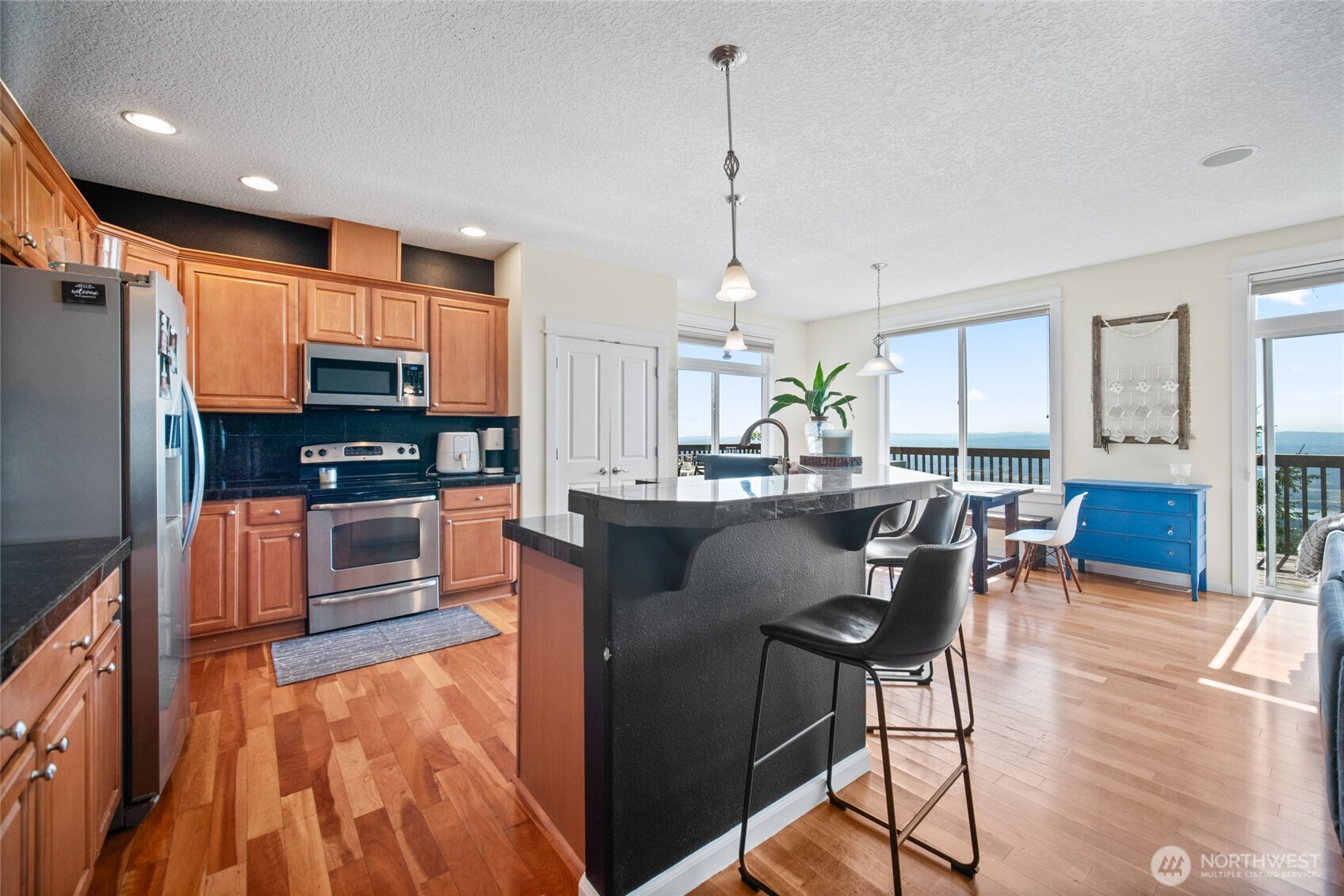 172 Blackjack Drive Kalama, WA 98625 - Photo 12 of 40 a kitchen with stainless steel appliances kitchen island granite countertop a refrigerator a stove a sink with a dining table and chairs