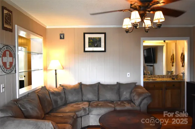a living room with furniture a chandelier and a large window