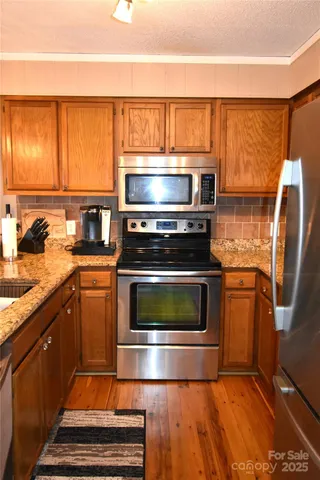 a view of a hallway with wooden floor and a bathroom