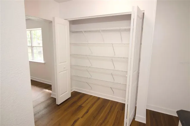 a view of empty room with wooden floor