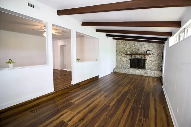 a view of an empty room with wooden floor