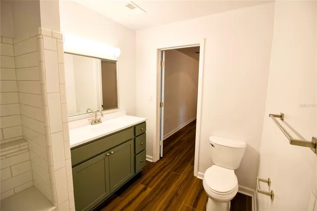 an empty room with wooden floor fan and window