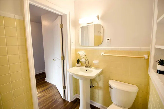a view of a hallway with wooden floor and closet area