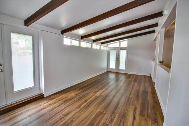 a view of empty room with wooden floor
