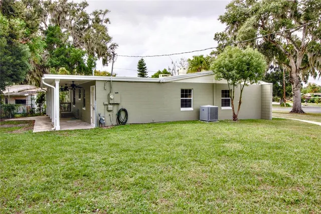 a view of a house with backyard and trees