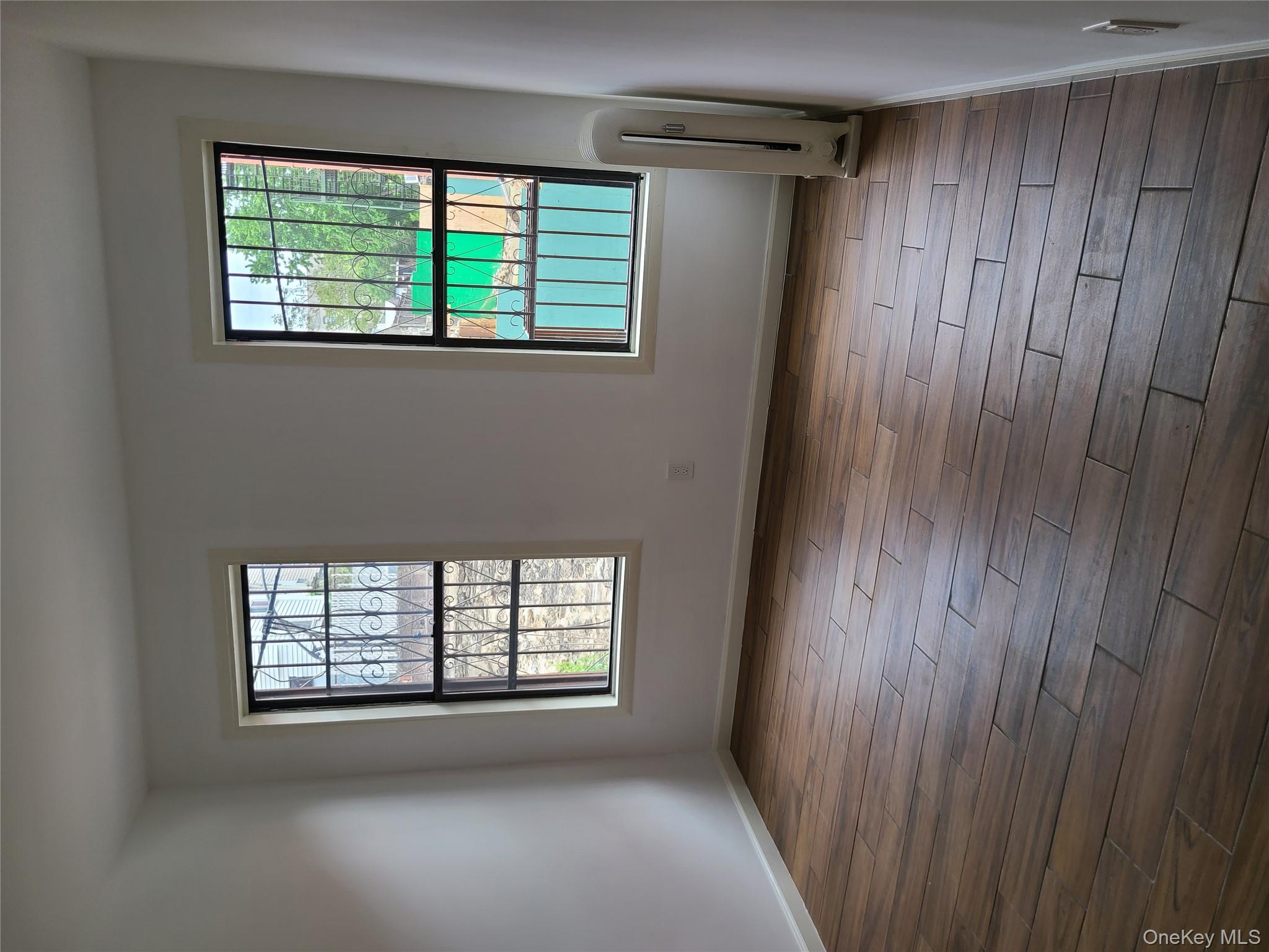 1309 Seneca Avenue Bronx, NY 10474 - Photo 11 of 20 an empty room with wooden floor and windows
