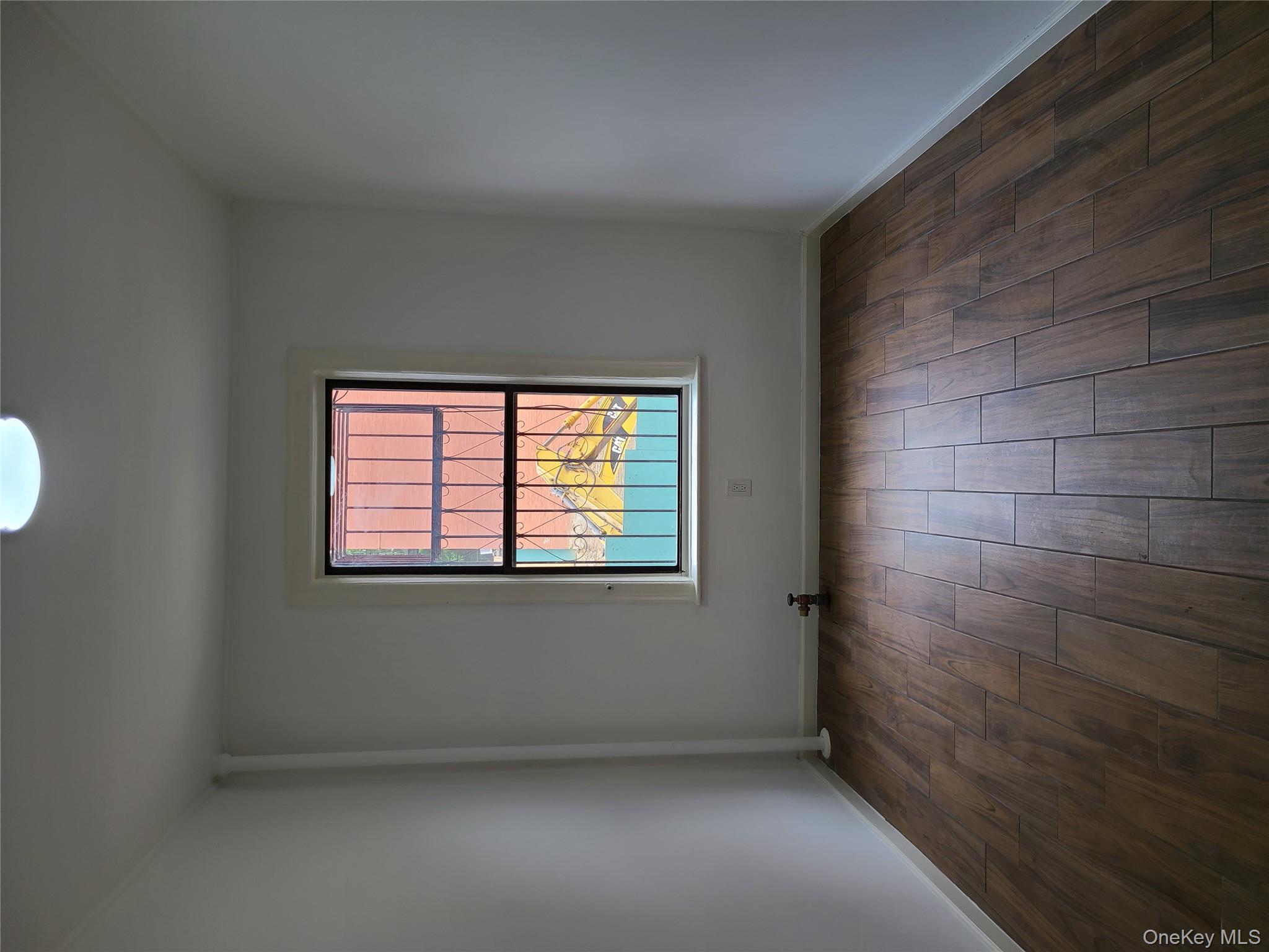 1309 Seneca Avenue Bronx, NY 10474 - Photo 12 of 20 an empty room with wooden floor and windows
