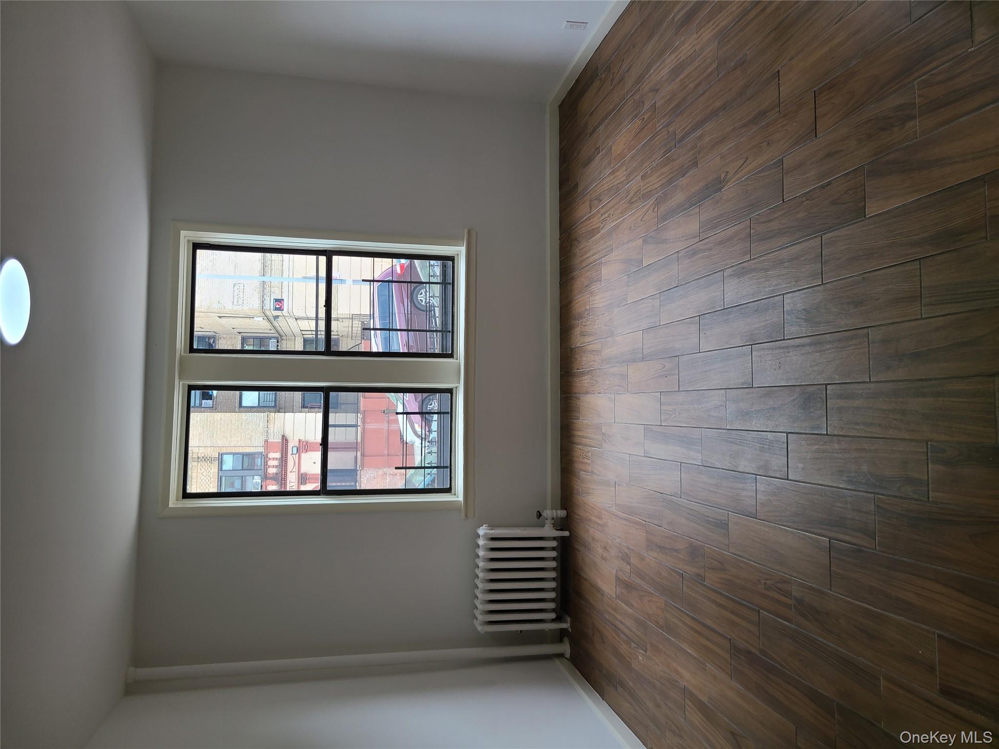 1309 Seneca Avenue Bronx, NY 10474 - Photo 18 of 20 an empty room with wooden floor and windows