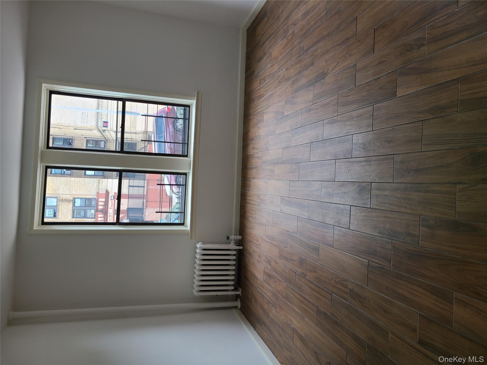 1309 Seneca Avenue Bronx, NY 10474 - Photo 19 of 20 an empty room with wooden floor and windows