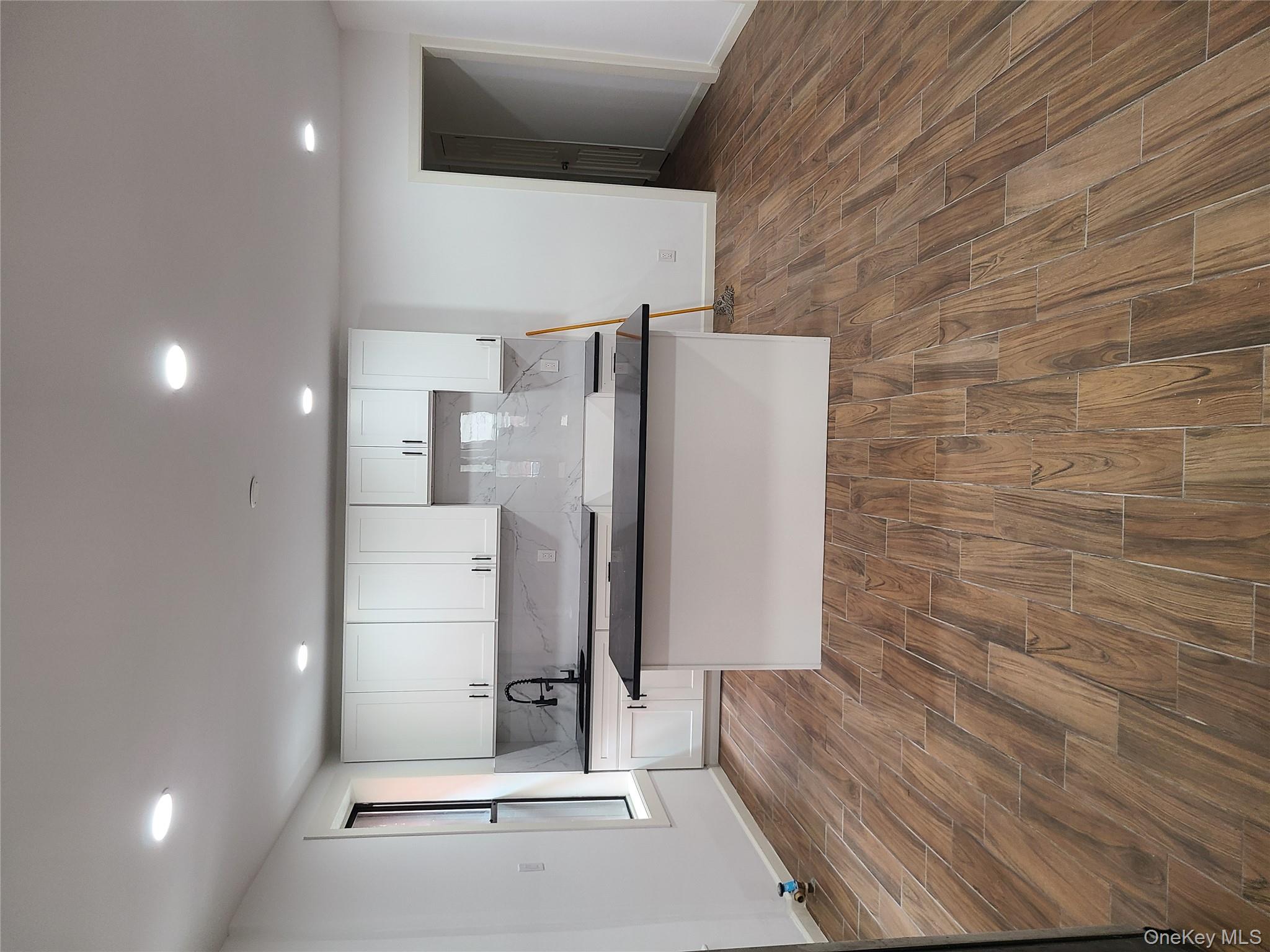 1309 Seneca Avenue Bronx, NY 10474 - Photo 20 of 20 a kitchen with stainless steel appliances granite countertop a sink stove and wooden floor