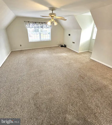 en empty room with windows and ceiling fan