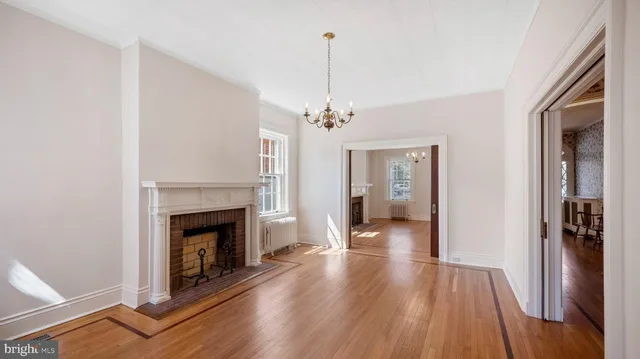 a view of a livingroom with wooden floor fireplace and windows