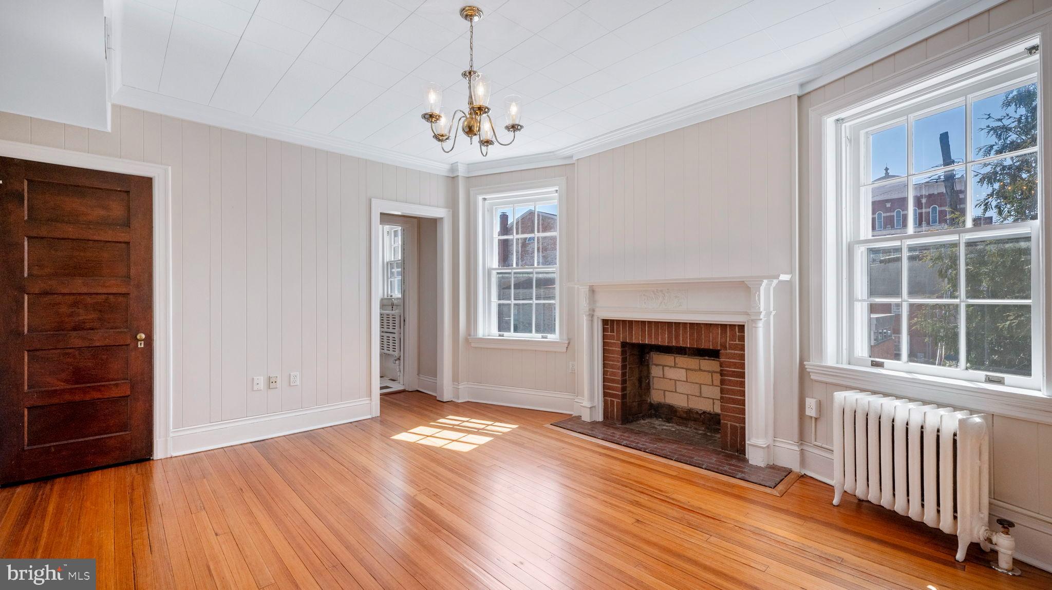 110 North Court Street Frederick, MD 21701 - Photo 23 of 28 an empty room with wooden floor fireplace and windows