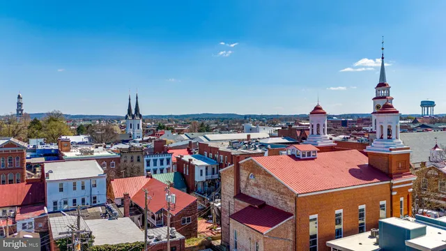 a car parked in front of a brick house with large trees