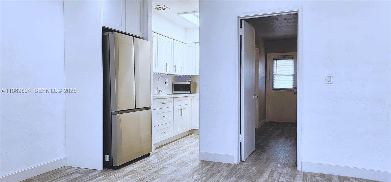 2901 Polk Street, Unit 14 Hollywood, FL 33020 - Photo 4 of 16 a view of a kitchen with refrigerator and wooden floor