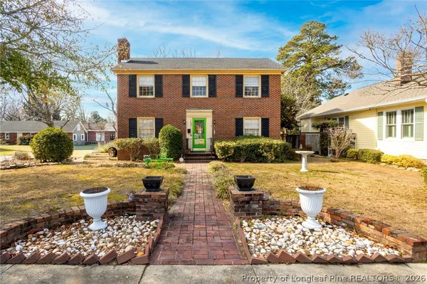 a front view of a house with swimming pool and a yard