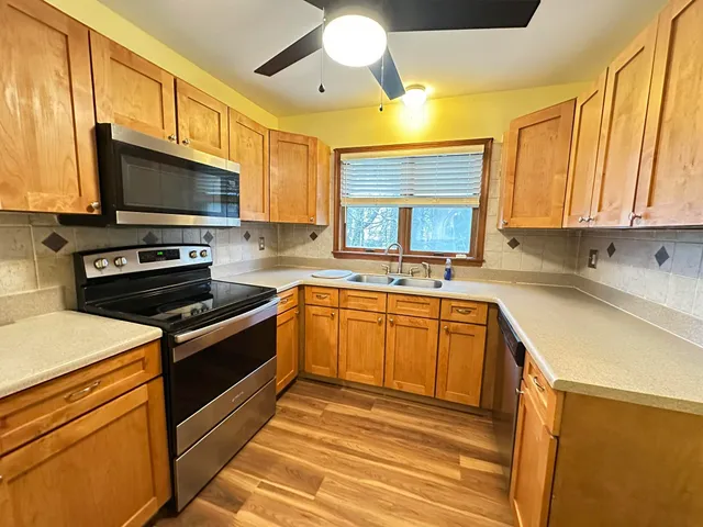 a kitchen with stainless steel appliances a stove sink and microwave