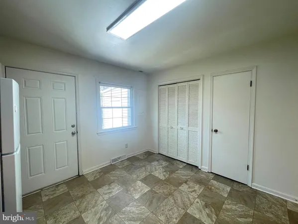 an empty room with closet and ceiling fan