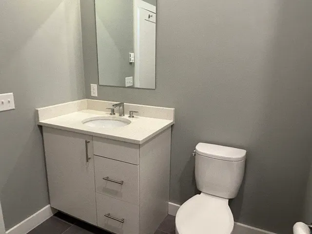 a bathroom with a toilet sink and mirror