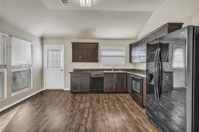 a kitchen with stainless steel appliances a refrigerator and a stove top oven